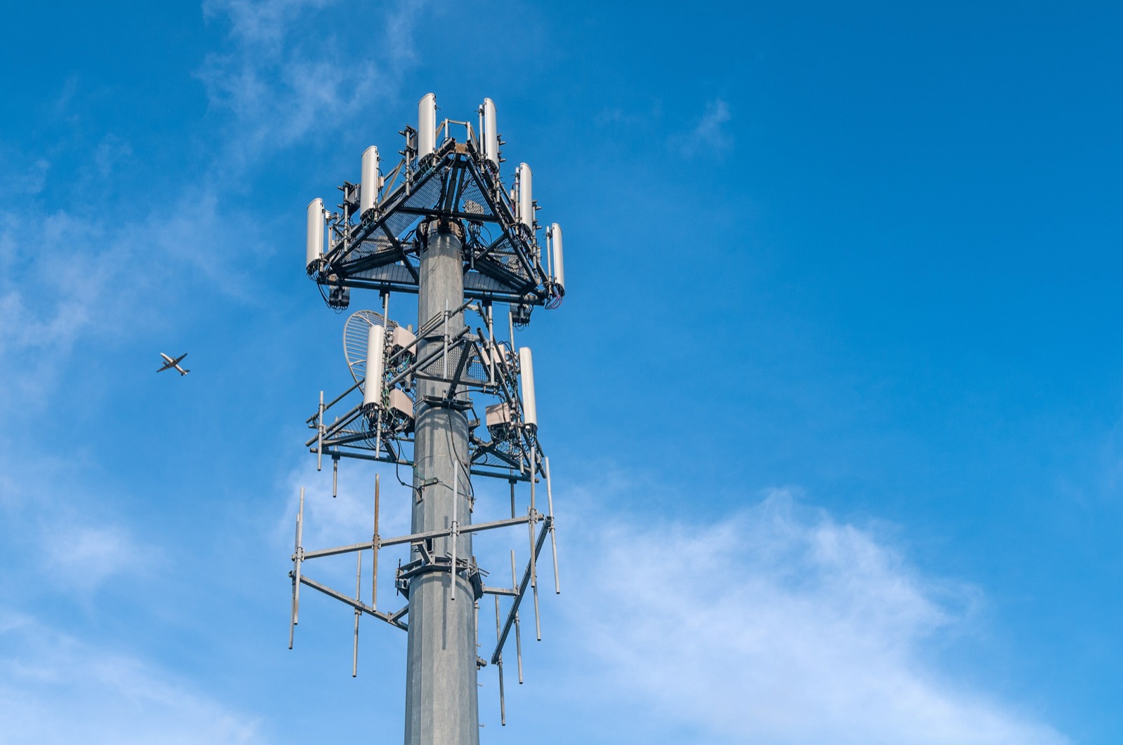 5G cell tower infrastructure against a clear blue sky