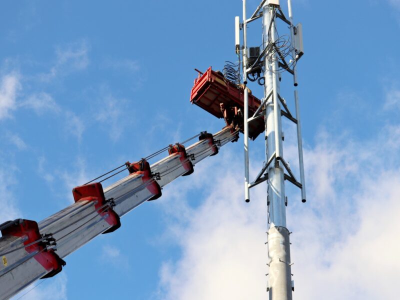 Crane lifting equipment during build-to-suit cell tower construction